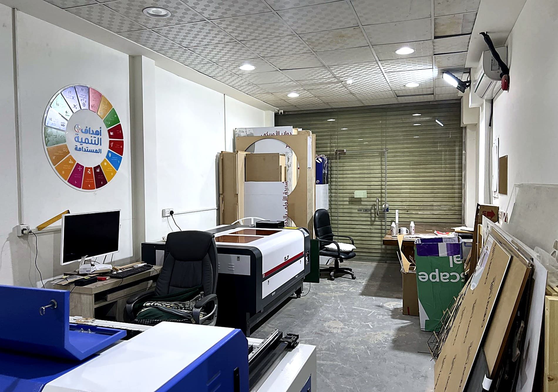 Inside the Darb Productions print house in Riyadh — the laser bed, vinyl cutters and the artwork station along one room