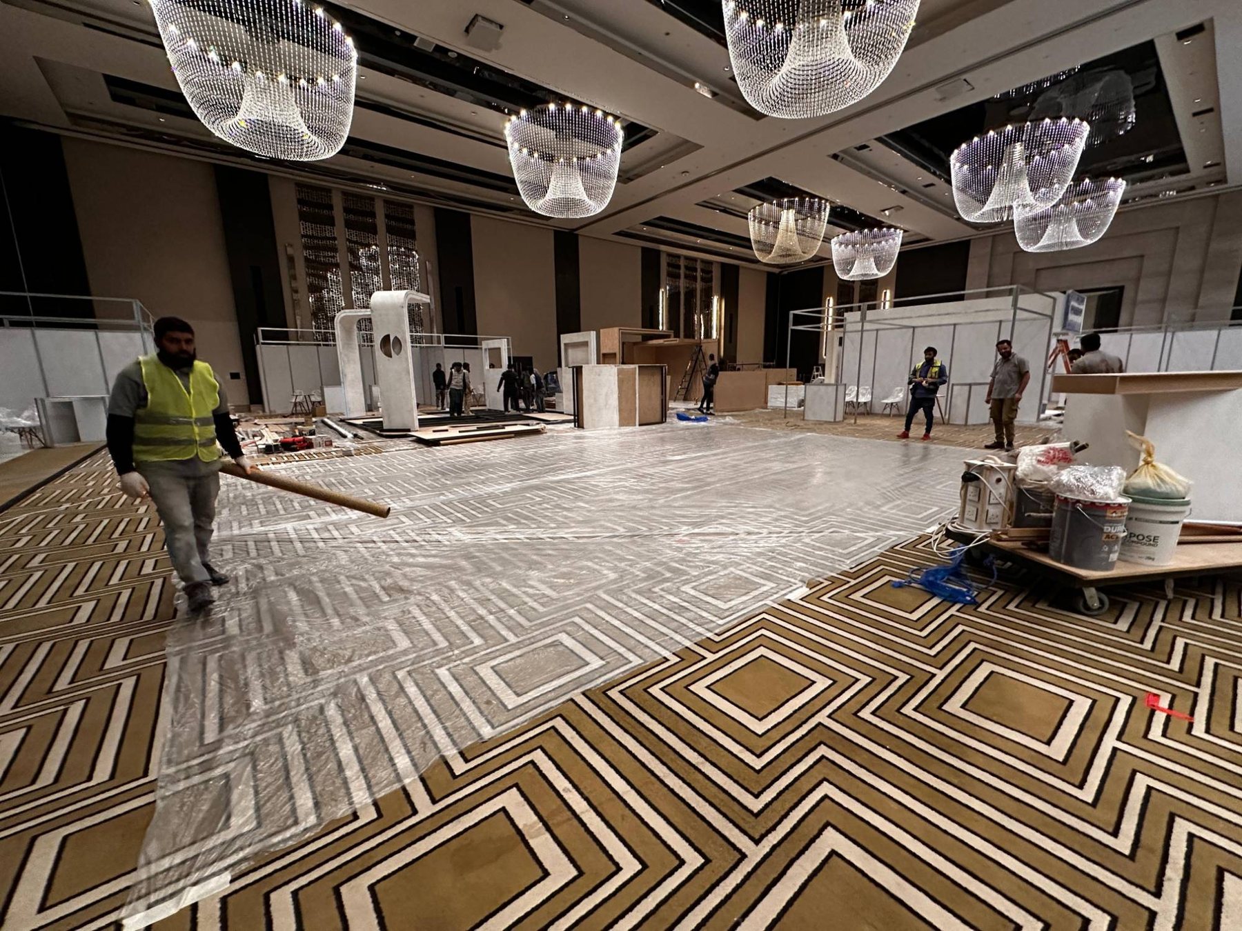 Darb crew laying floor protection across a hotel ballroom before an exhibition build in Riyadh