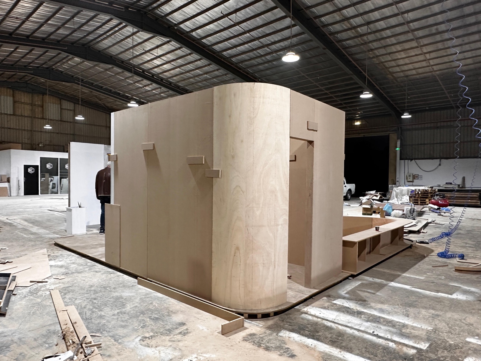 Custom exhibition booth with curved plywood facade fabricated for a Riyadh event by Darb Productions