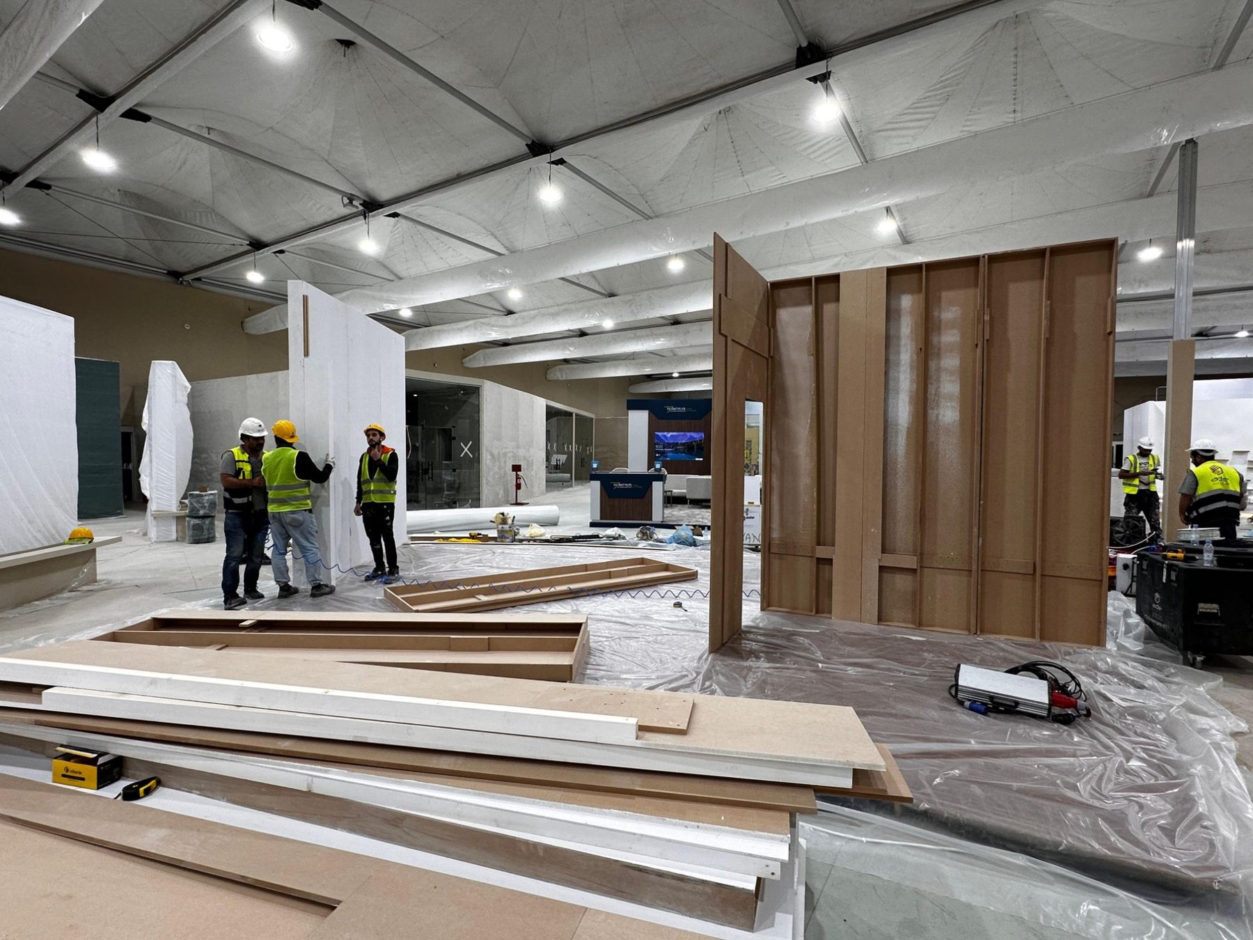 Darb crew erecting MDF stand walls inside an exhibition pavilion in Riyadh